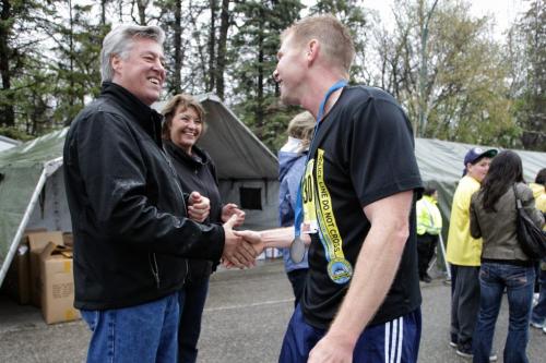 Winnipeg Police Chief Keith McCaskill congratulates a participant of the marathon at the finish line.  Around 1,900 people took part in the Winnipeg Police Service half-marathon this morning. The eighth annual event started and finished at Assiniboine Park and is expected to raise about $100,000 for Cops for Cancer. Organizers had initially expected about 2,500 participants, but said the weather may have dissuaded some people from coming out. See Jen Skerritt story 120506 May 06, 2012 Mike Deal / Winnipeg Free Press