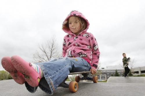 Elleana Wiebe of Niverville prepares to ride down a ramp, under the watchful eye of her older brother, Jett, at the skate park at The Forks on Tuesday. May 08, 2012. SARAH O. SWENSON / WINNIPEG FREE PRESS