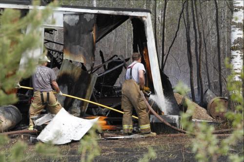 Firefighters work to extinguish the remains of a trailer that was destroyed by a forest fire near Vita, in southwestern Manitoba on Monday. May 14, 2012. SARAH O. SWENSON / WINNIPEG FREE PRESS
