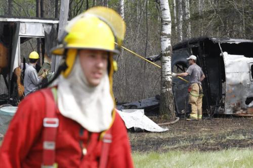 Firefighters work to extinguish the remains of a trailer destroyed be forest fires near Vita, in southeastern Manitoba, on Monday. May 14, 2012. SARAH O. SWENSON / WINNIPEG FREE PRESS