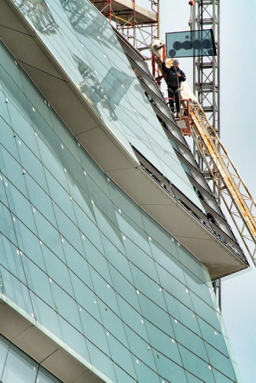 A construction worker installs a windowpane on the Canadian Museum For Human Rights at the Forks. 120516 May 16, 2012 Mike Deal / Winnipeg Free Press CMHR