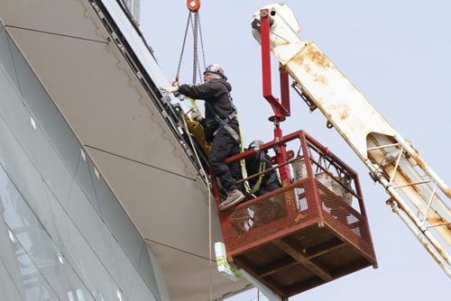 Construction workers in a crane basket install a pane of glass at the Canadian Museum for Human Rights at The Forks on Wednesday. Workers have begun to install the glass on the Tower of Hope, the 23-storey glass structure at the pinnacle of the museum. Construction is projected to be complete in 2012. May 16. 2012. SARAH O. SWENSON / WINNIPEG FREE PRESS CMHR