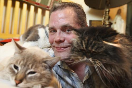 Darcy Canty with his 3 cats - scraggly persian cate "Kiki" (right) and his two other's at his home. Names of cats - "Kiki" dark Persian, "Jinxy" cream and "Sylvestor" black and white. See Gordon Sinclair story Photo Ruth Bonneville Winnipeg Free Press