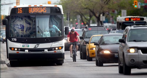 A cyclist manouvers around a stopped transit bus in the bus/bike lane on Main street between Pioneer and Portage ave Wednesday afternoon . See story. May 16, 2012 - (Phil Hossack / Winnipeg Free Press)