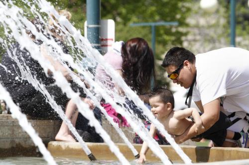 Kojak Kyle Keith Woods reaches into the fountain on Manitoba Plaza at the Legislative Building with a little help from his father, Christopher Michelle. Winnipeggers were looking for all sorts of ways to cool down on Thursday as the temperature hit 28 °C. (from the Weather Network)  May 17, 2012. SARAH O. SWENSON / WINNIPEG FREE PRESS
