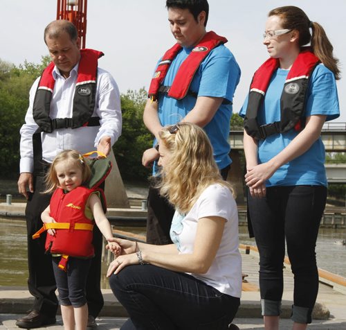 Avery Davin, age 3, with her monther Jenny, demonstrate how a child should properly wear a life jacket during a presentation for Safe Boating Awareness Week at The Forks on Friday. The province announced Safe Boating Awareness Week will run May 19-25. (back row l-r: Healthy Living, Seniors and Consumer Affairs Minister Jim Rondeau with Lifesaving Society members Jon Sorokowski and Kassandra Webster). May 18, 2012. SARAH O. SWENSON / WINNIPEG FREE PRESS