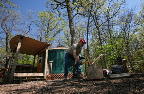 Brandon Sun Drew Richardson splits wood for the fire outside one of the yurts set amongst the oaks at the Kiche Manitou campground in Spruce Woods Provincial Park. For Charles. (Bruce Bumstead/Brandon Sun)