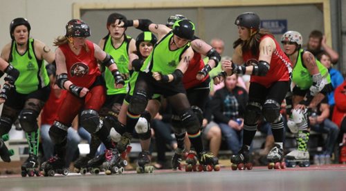 Brandon Sun Shenna Ford, centre, A.K.A. SheNasty N2O, breaks through the pack for the Westman Gang Greens during Saturday night's Wheat City Roller Derby League's bout against the visiting Lil Chicago Roller Derby team from Moose Jaw at CFB Shilo. (Bruce Bumstead/Brandon Sun)