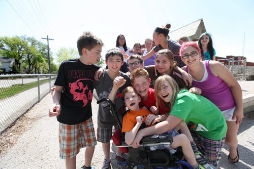 Seven year old Tyler is the centre of attention surrounded by his sister Emily (right in green shirt), big brother Griffin (red shirt) and  Griffins grade 7 classmates who gathered together on their play structure over their lunch hour at Windsor School.  The class is doing a fundraising activity to replace the structure with one that can include kids like Tyler in wheelchairs. For the ongoing series on the class of 2017 at Windsor School. See Doug Speirs story. May 28  2012 (Ruth Bonneville/Winnipeg Free Press)