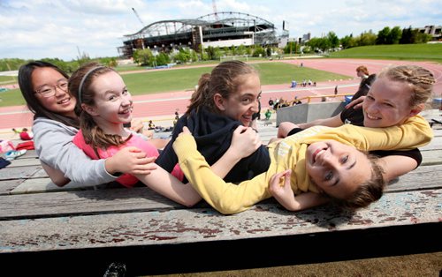 A group of grade 7 girls lock arms as they hang out together while competing at their city wide track meet at Max Bell track.  Names from left  - Han, Sidney Shaelyn, Aby and Heiley. See Doug Speirs story Windsor School 2017 project. May 28  2012 (Ruth Bonneville/Winnipeg Free Press)