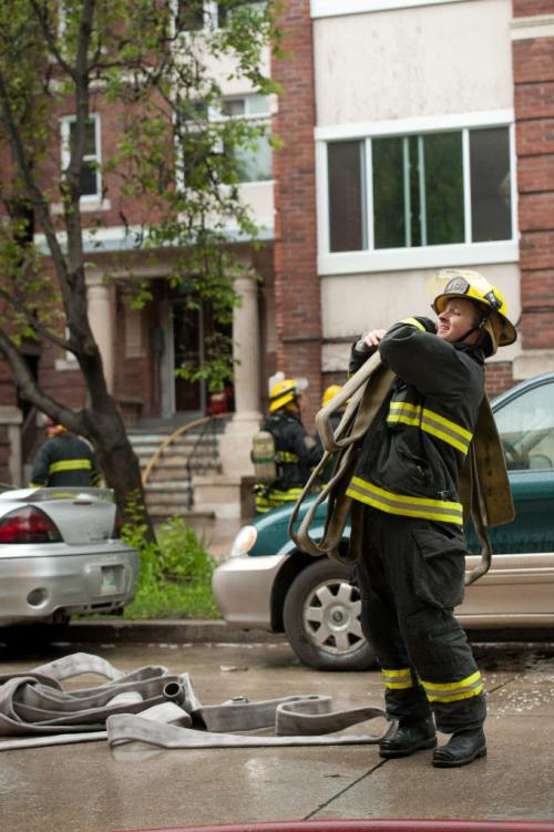 A Winnipeg firefighter cleans up hosing after responding to a fire in the King George Court apartment building at the corner of Cockburn Avenue and Jessie Avenue in the Corydon area of Winnipeg on May, 29, 2012.  Smoke was seen coming from a second-story window in the rear of the building. (Photo by Cole Breiland/ Winnipeg Free Press) Winnipeg Free Press