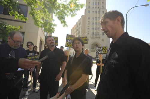 Eric Reader of the Wilderness Committee addresses the media beside Josh Brandon of the Green Action Centre (centre) and Ron Thiessen of CPAWS (left) about the Black Out Speak out Protest outside the Canadian Grain Commission Building on Main Street in downtown Winnipeg on June 4th, 2012. Black Out Speak Out will see participating websites shut down to protest the omnibus bill C-38, that they claim will harm meaningful environmental review of industrial projects in Canada. (Photo by Cole Breiland / Winnipeg Free Press) Winnipeg Free Press
