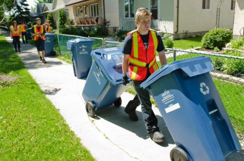 Brian Dies delivers a new and bigger blue bin for recycling on Downing Street west of downtown Winnipeg, on June 4th 2012.  Residents will not be able to use the bins until August or October depending on the area of the city in which they reside. (Cole Breiland / Winnipeg Free Press) Winnipeg Free Press
