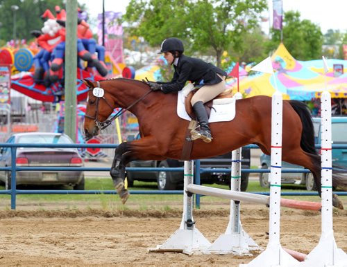Brandon Sun Chelsea Van Schie of Thunder Bay, Ontario leaps over an obstacle as she and her horse warm up for the Hunter/Jumper competition in the Manitoba Summer Fair horse show, Friday afternoon. Forty-five competitors are taking part in the event, which is run by the Provincial Exhibition as part of the fair. (Colin Corneau/Brandon Sun)