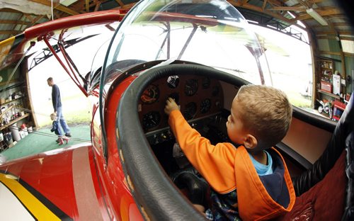 Jones Menge, 2, checks out the cockpit of Gilbert Bourrier's Acrosport II bi-plane at the Lyncrest Airfield, as part of the Western Canada Aviation Museum's Flyin' BBQ, Saturday, June 16, 2012. (TREVOR HAGAN/WINNIPEG FREE PRESS)