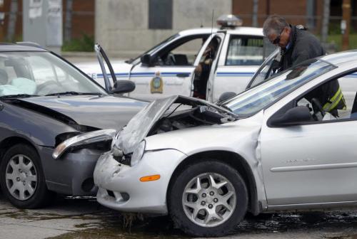 A responder folds the airbag inside one of 2 cars involved in a collision at the corner of Salter Street and Dufferin Avenue, just north of the Salter Bridge, Saturday, June 16, 2012. (TREVOR HAGAN/WINNIPEG FREE PRESS)