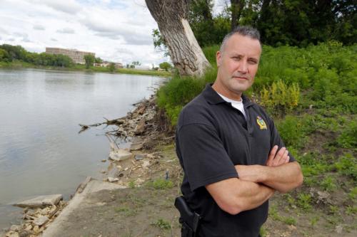 A Winnipeg police officer Const. Kevin Gibson who rescued a 15-year-old boy from the Red River Sunday afternoon had to be rescued himself after he became stuck in the river mud. Here he poses for a photo in the area of the incident. June 20, 2012  BORIS MINKEVICH / WINNIPEG FREE PRESS