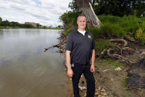 A Winnipeg police officer  Const. Kevin Gibson who rescued a 15-year-old boy from the Red River Sunday afternoon had to be rescued himself after he became stuck in the river mud. Here he poses for a photo in the area of the incident. June 20, 2012  BORIS MINKEVICH / WINNIPEG FREE PRESS