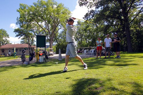 Andrew Littleford tees off with his band (in background) called the Dirty Catfish Brass Band. Windsor Park Golf course. June 29, 2012  BORIS MINKEVICH / WINNIPEG FREE PRESS