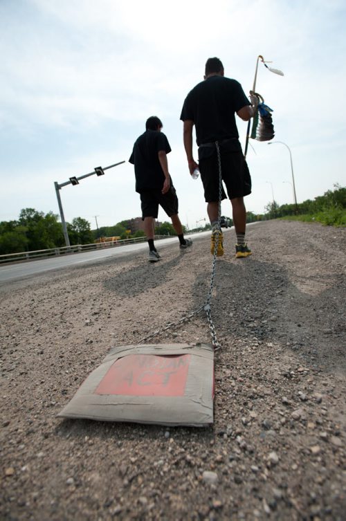 120702 Winnipeg - Leo Baskatawang and Ashley walk on Fermor Avenue as they leave Winnipeg to continue their journey to Ottawa, dragging a copy of the Indian Act behind them. They have been on the road 71 days and expect to arrive in Ottawa near Labour Day. STORY. June 02 2012. COLE BREILAND / WINNIPEG FREE PRESS