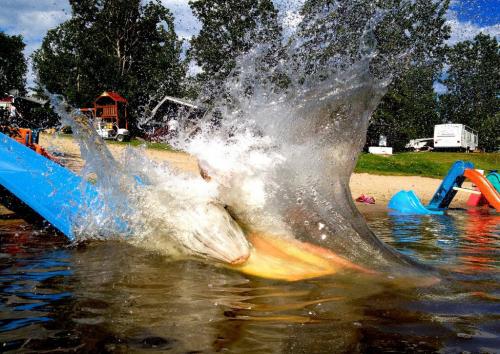 Two girls are masked by a wall of water as they slide into Longbow lake this Canada Day weekend. Redden's camp near Kenora was packed with campers trying to beat the heat. The camp just painted the slide and it really sped the kids along into the lake. June 30, 2012  BORIS MINKEVICH / WINNIPEG FREE PRESS