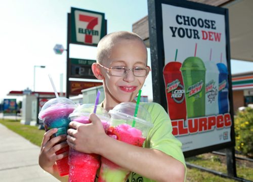 Nine year old  Aidan Pratt  enjoys his favorite slurpee flavor-creme soda and lime-Thurdsay afternoon while helping his mom Kristina Pratt bring home some slurpee's home for the family after a hot and muggy July day. The Seven Eleven store at 3021Ness Ave has won the World Slurpee store title again this year after selling the most slurpee's.   See story. July 05,  2012 (Ruth Bonneville/Winnipeg Free Press)