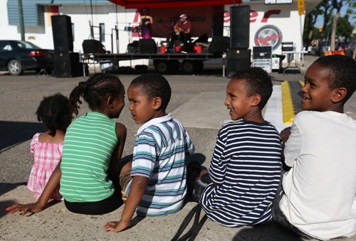 Brandon Sun Children listen to Winnipeg Latin music group Trio Bembe during the Summer Multicultural Festival at the new Global Marketplace at Twelfth Street and Rosser Avenue, Friday evening. The festival continues today with music and games in Princess Park and the market. (Colin Corneau/Brandon Sun)