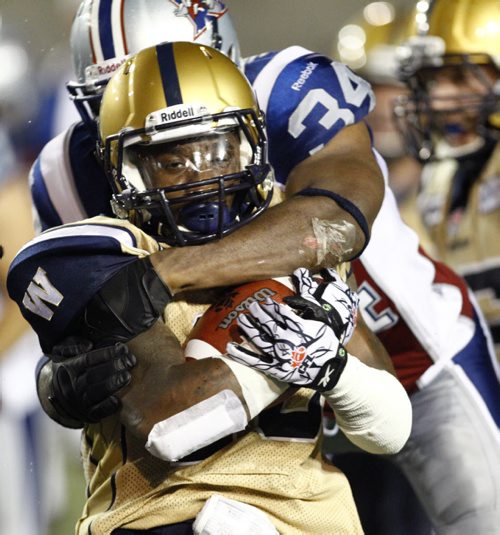 Winnipeg Blue Bombers Desmond Washington (front) is tackled by Montreal Alouettes Kyries Hebert (34) during the second half of their CFL football game in Montreal, July 6, 2012. REUTERS/Olivier Jean(CANADA - Tags: SPORT FOOTBALL)