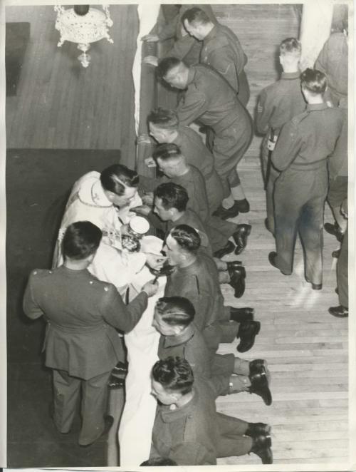 Winnipeg Free Press Archives
Winnipeg WWII Home Front
April 15, 1940
Soldiers Receive Communion About 250 Roman Catholic soldiers from Fort Osborne barracks attended mass Sunday morning in St. Joseph's Vocational school chapel. Following the mass, breakfast was served for the communicants. The breakfast, which was sponsored by the Knights of Columbus, was served by the Sisters, members of the Ladies' auxiliary of the school, and Amicus club girls. The picture shows the soldiers receiving communion.
