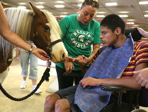 Brandon Sun Brenew Brass gets a close-up look at "Candy", a pony used during a visit by special-needs children organized by the Society for Manitobans with Disabilities, Monday afternoon at the Keystone Centre. FOR CHARLES STORY (Colin Corneau/Brandon Sun)