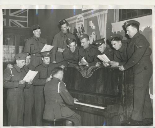 Winnipeg Free Press Archives
Winnipeg WWII Home Front
April 6, 1940
All happy and gay Soldiers stationed in the Winnipeg district will not lack recreation. Here is the Knights of Columbus army hut, opened informally on Main street and Graham Avenue Friday. Among the first to use the spacious new premises are the group shown above, trying out the piano.