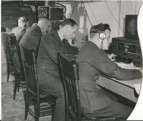 Winnipeg Free Press Archives
Winnipeg WWII Home Front
November 16. 1943
Left, student signals officers of the R.C.A.F. at work in their home-made radio station in the basement of the Merchants' hotel, Selkirk, Monday afternoon. At the time the picture was taken a twoway conversation was going on between the station and PO. J. Burrell, a returned wireless air gunner, circling over Selkirk in a Norseman plane of No. S Wireless school. Left to right, Pilot Officers H. E. Brownhili, Halifax. N.S.: E. W. Collins, Southseat, England: Stan Stuka, Warsaw, Poland, and H. M. Field, Grande Prairie, Alta. Right, two of the first group of girl signals officers of the R.C.A.F., training at the Tuxedo school, Officer Cadets Neil Ross, Vancouver (left), and Louise Le Clair, North Hustico. P.E.I., operate the VHF (Very High Frequency) transmitter at No. 3 Wireless school. The girls previously qualified- as ground wireless operators at No. 1 Wireless school. Montreal.