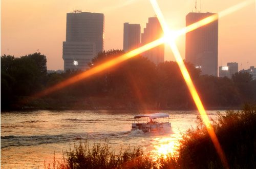 A pontoon boat speeds along the Red River just north of the Provencher Bridge in the hazy setting sun Saturday evening. See Matt Prepost weather story. July 12, 2012 Ruth Bonneville Winnipeg Free Press