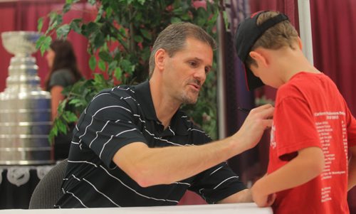 Brandon Sun Legendary NHL goaltender Ron Hextall signs Keegan Drysdale's t-shirt on Monday during a visit to the Wheat City with the Stanley Cup. (Bruce Bumstead/Brandon Sun)