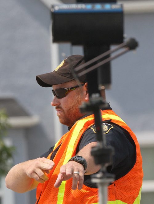 A Winnipeg Police officer directs a speeder in for a ticket after using a laser speed gun to catch speeding Winnipegers coming down the Northbound hump of the Slaw Rebchuk bridge Tuesday- July17, 2012   (JOE BRYKSA / WINNIPEG FREE PRESS)