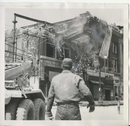Winnipeg Free Press Archives Time Building Fire  (10)  June 11, 1954 Part of the front wall of the Edwards block, gutted by fire, is sent crashing- to the ground' as three crane trucks with thousands of feet of steel cable tugged at its girders. Hundreds of onlookers pushed their way past police lines on Portage avenue to get a closer look at the wrecking crew's work. As the building fell, road, and pavement shuddered under the impact. fparchive