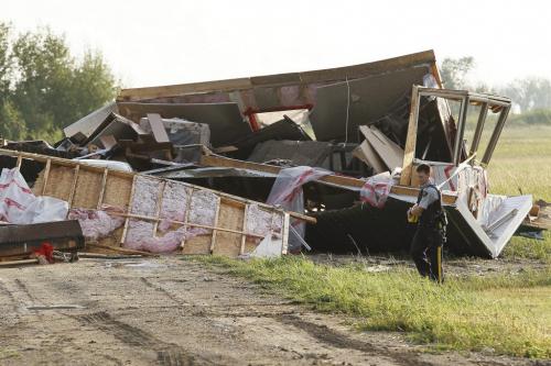 July 29, 2012 - 120729  -  An RCMP officer tapes off a scene after strong winds and possibly a tornado lifted this home off of it's foundation and turned it upside down on Lake Francis Road just south of Twin Beach Road and south of St. Laurent, Manitoba Sunday July 29, 2012.    John Woods / Winnipeg Free Press