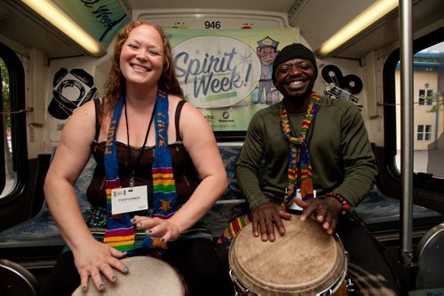 120813 Winnipeg - Diana Lavergne and Evans Cuffie from the African pavillion at Folklorama play on a Downtown Spirit Week bus while stopped at the Forks. Riders on the designated buses will have a chance see a variety of entertainment and to win prizes. Popularity of the buses is rising with 9,233 people riding the Downtown Spirit buses last year. August 13 2012. COLE BREILAND / WINNIPEG FREE PRESS