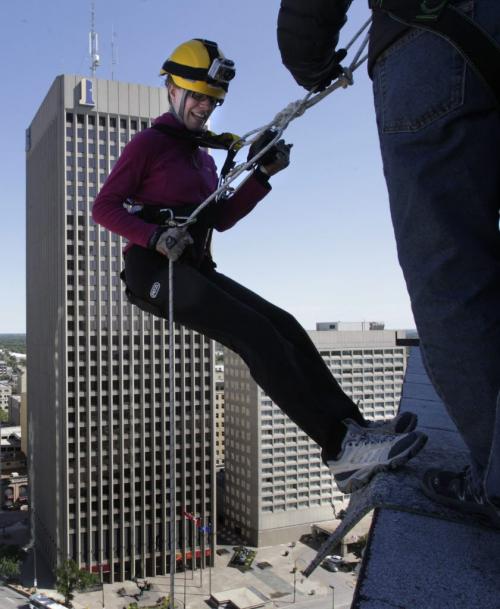 Free Press reporter Jennifer Ford begins to rappel down 17 stories of the RBC building on Portage Ave. Thursday taking part in the annual Easter Seals Drop Zone. All proceeds raised stay here in Manitoba to support Manitobans with disabilities.   (WAYNE GLOWACKI/WINNIPEG FREE PRESS) Winnipeg Free Press  Aug. 16  2012