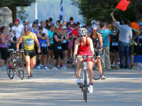 Brandon Sun Competitors grab their bicycles for the cycing portion of their race on the main beach at Wasagaming at the annual Riding Mountain Triathlon in Clear Lake, Saturday morning. (Colin Corneau/Brandon Sun)