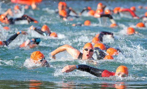 Brandon Sun Competitors hit the water for the swim portion of their race on the main beach at Wasagaming at the annual Riding Mountain Triathlon in Clear Lake, Saturday morning. (Colin Corneau/Brandon Sun)