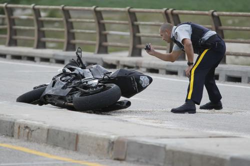 August 26, 2012 - 120826  -  RCMP officers investigate an MVC involving a RCMP cruiser and a motorcycle in the southbound lanes the north Floodway bridge on highway 59 Sunday August 26, 2012.    John Woods / Winnipeg Free Press