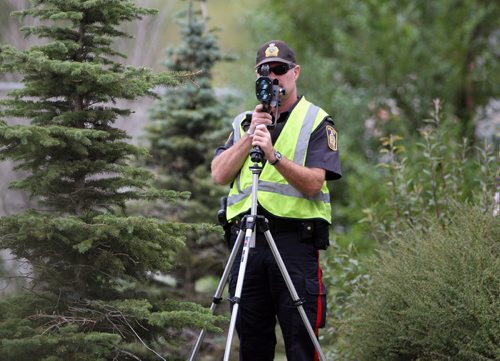 A Winnipeg traffic officer uses the cover of trees to nap speeders on Route 90 just north of the Portage Ave overpass - Standup Photo August 27, 2012   (JOE BRYKSA / WINNIPEG FREE PRESS)