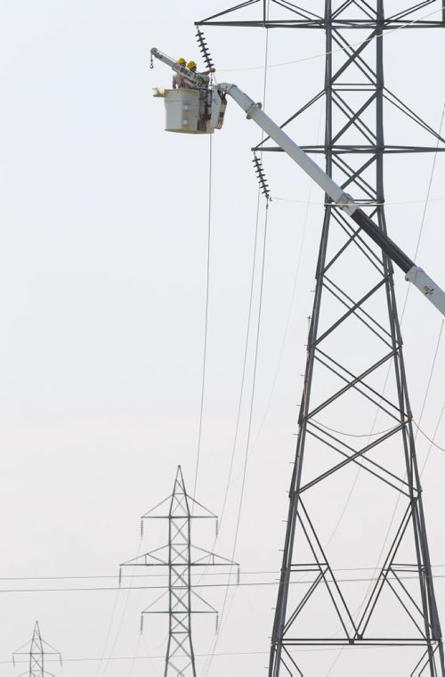 Brandon Sun Hydro workers to install transmission lines on the new towers running along Richmond Avenue East near the Maple Leaf Plant on Wednesday afternoon. (Bruce Bumstead/Brandon Sun)