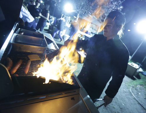 Brandon Sun Kelsey Jennsens is lit by the grill as she prepares snacks for students during the 7th annual Rock the Block concert, Friday night in downtown Brandon. The festival has become a traditional celebration of the first week of post-secondary classes in the city. (Colin Corneau/Brandon Sun)