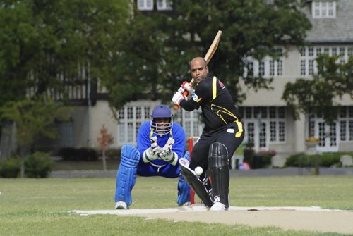 A premier cricket match between Cosmos (black) and Bloomfield (blue) at the Assiniboine Park pitch Sunday afternoon. Batsman for Cosmos, Keith Deonaraine, swings at the ball during the afternoon match. 120916 - Sunday, September 16, 2012 -  (MIKE DEAL / WINNIPEG FREE PRESS)