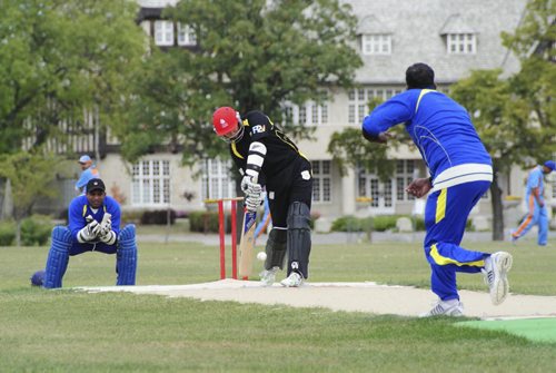A premier cricket match between Cosmos (black) and Bloomfield (blue) at the Assiniboine Park pitch Sunday afternoon. Batsman for Cosmos, Waleed Ahmed, hits a four during the afternoon match. 120916 - Sunday, September 16, 2012 -  (MIKE DEAL / WINNIPEG FREE PRESS)