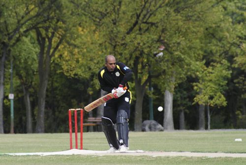 A premier cricket match between Cosmos (black) and Bloomfield (blue) at the Assiniboine Park pitch Sunday afternoon. Batsman for Cosmos, Keith Deonaraine, hits the ball for a single during the afternoon match. 120916 - Sunday, September 16, 2012 -  (MIKE DEAL / WINNIPEG FREE PRESS)