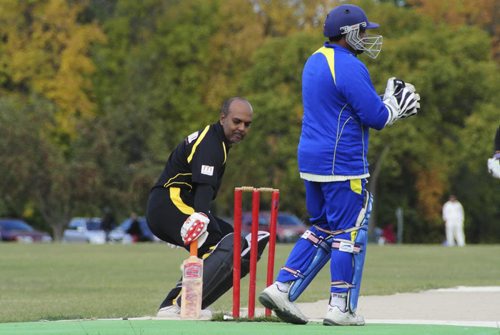 A premier cricket match between Cosmos (black) and Bloomfield (blue) at the Assiniboine Park pitch Sunday afternoon. Batsman for Cosmos, Keith Deonaraine, touches the base during the afternoon match. 120916 - Sunday, September 16, 2012 -  (MIKE DEAL / WINNIPEG FREE PRESS)