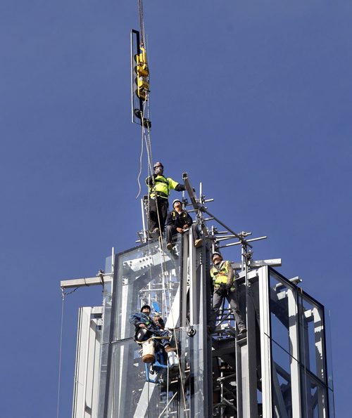 Workers on the Canadian Museum for Human Rights wait for the crane to lower the last piece of glass Thursday to be installed on the Museums Tower of Hope that stretches to 100 meters. Geoff Kirbyson story  (WAYNE GLOWACKI/WINNIPEG FREE PRESS) Winnipeg Free Press  Sept. 20  2012 CMHR